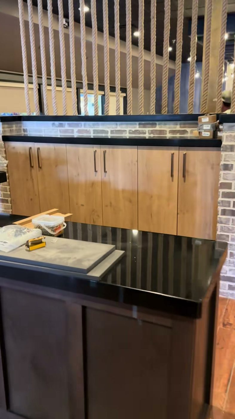Restaurant bar with wood slat feature wall and black counter