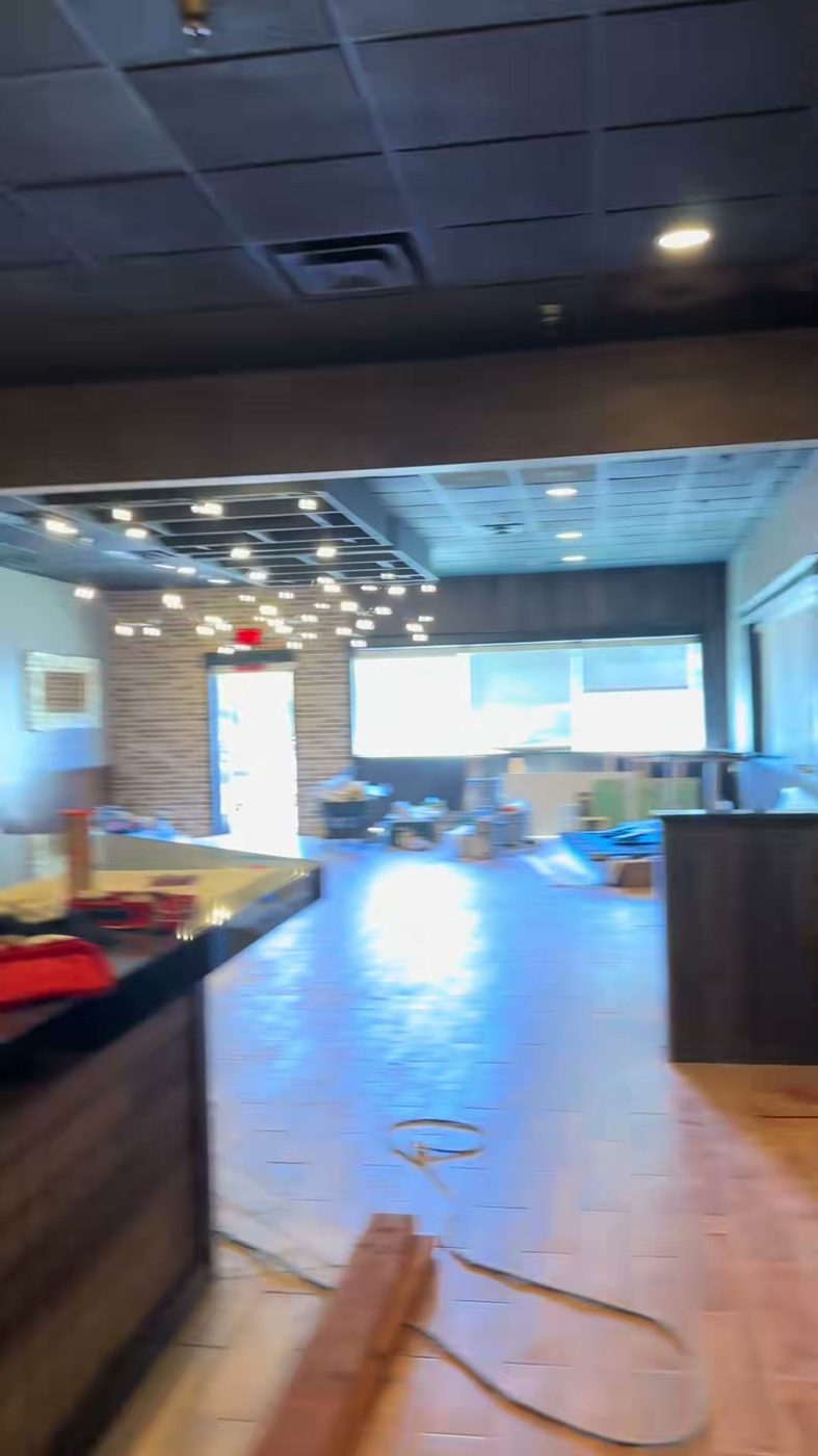 Restaurant tenant improvement with dark ceiling, wood floors and brick accent wall